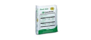 A white and green bag of Seed Aide CoverGrow, a product for grass seed and soil protection, shown standing upright with the product label, usage instructions, and tables visible on the front.