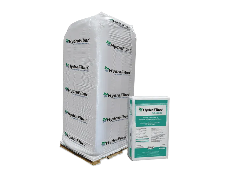 A large white pallet wrapped in plastic and labeled HydraFiber stands next to a smaller HydraFiber EZ Blend product box with green and white labeling, against a plain white background.