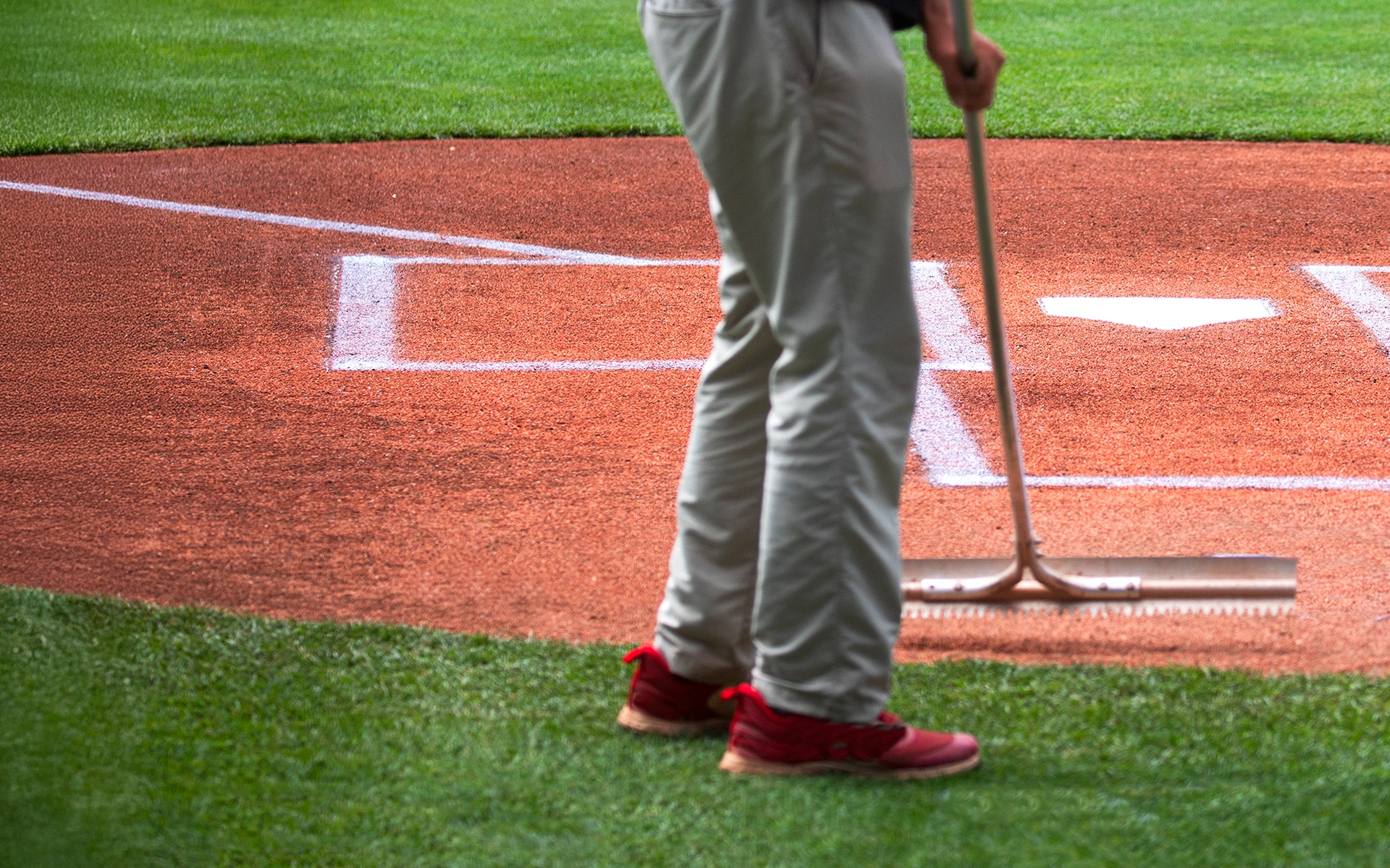 Grounds crew raking clay.