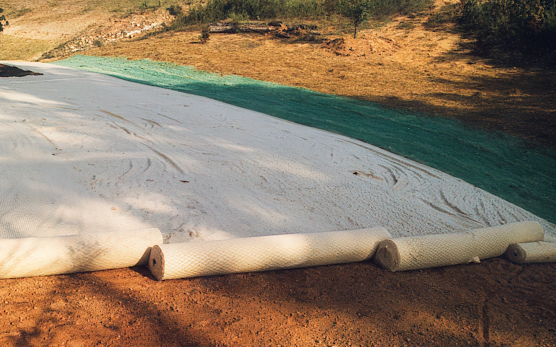 Applying rolled landscaping product.