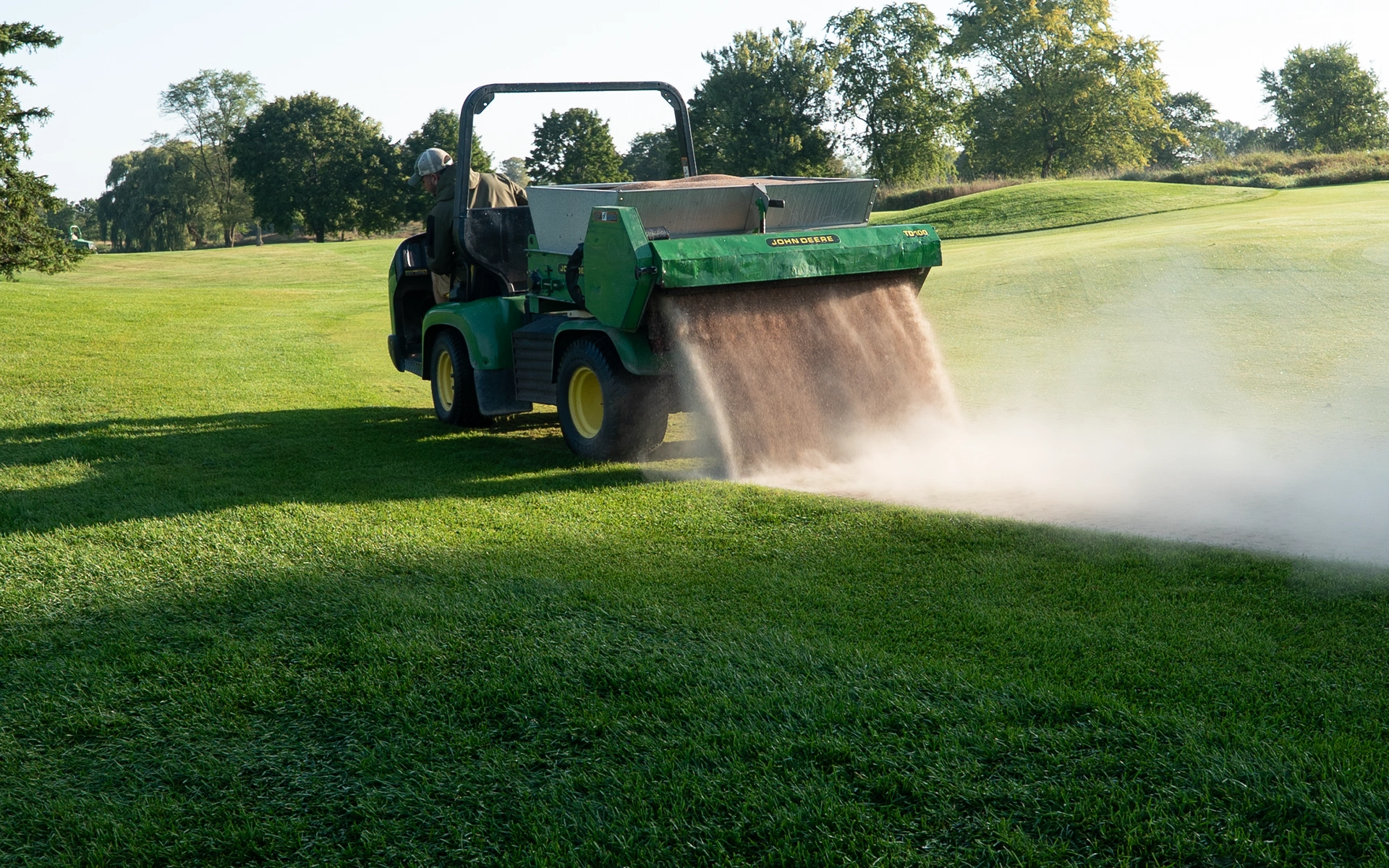 Lawn equipment applying soil amendments.