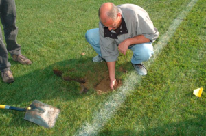 Coach repairing turf.