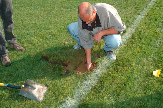 Coach repairing turf.