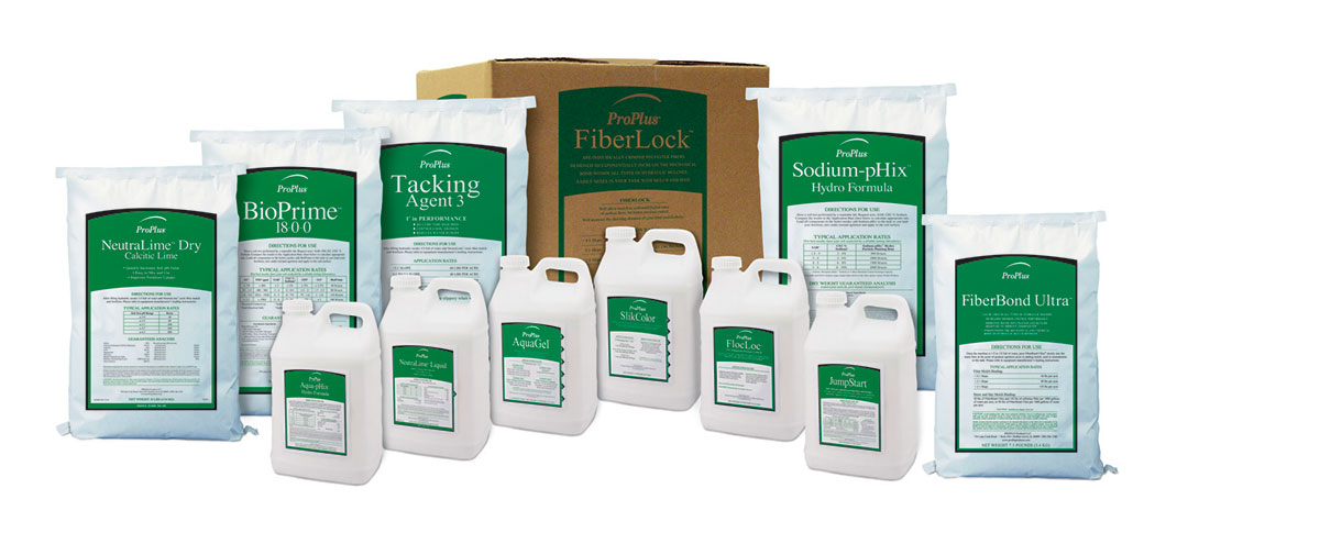A group of white bags and jugs with green and white labels, arranged in front of a cardboard box labeled FiberLock. The products appear to be industrial or agricultural chemicals.