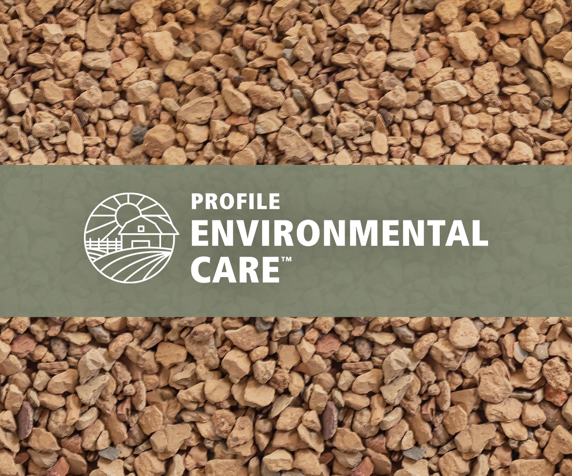 A background of small, reddish-brown gravel stones with a green banner across the center displaying a logo of a barn and fields and the words PROFILE ENVIRONMENTAL CARE™.