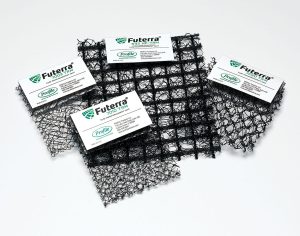 Four black mesh samples with Futerra labels are displayed on a white background. Each sample shows a different mesh pattern and texture, illustrating various erosion control matting options.
