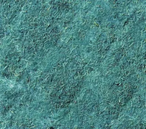Close-up texture of green hydroseed mulch showing fibrous strands and small debris forming a protective ground layer.