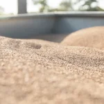 Close-up of tan porous ceramic granules forming small mounds, with a shallow depth of field.
