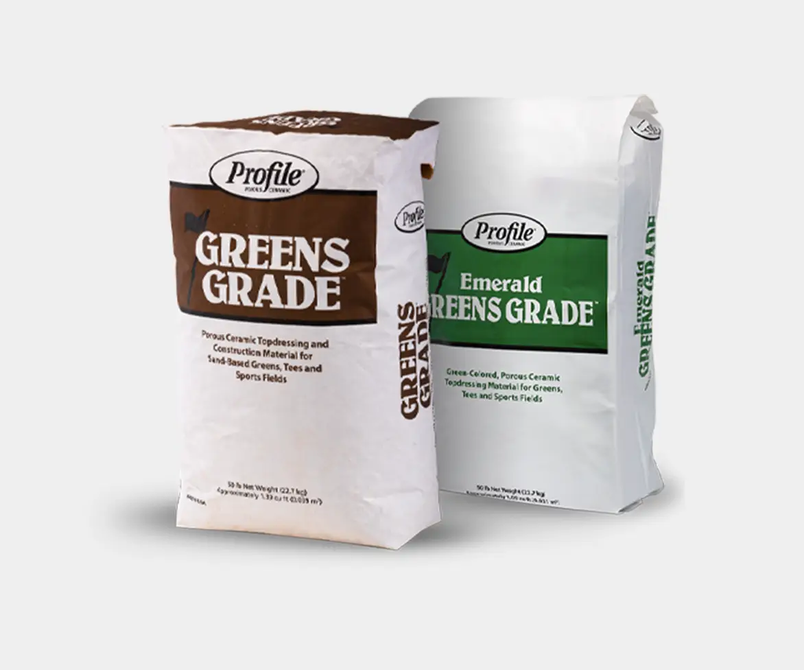 Two bags of Profile porous ceramic topdressing labeled “GREENS GRADE” (brown panel) and “Emerald GREENS GRADE” (green panel) displayed side by side on a white background.