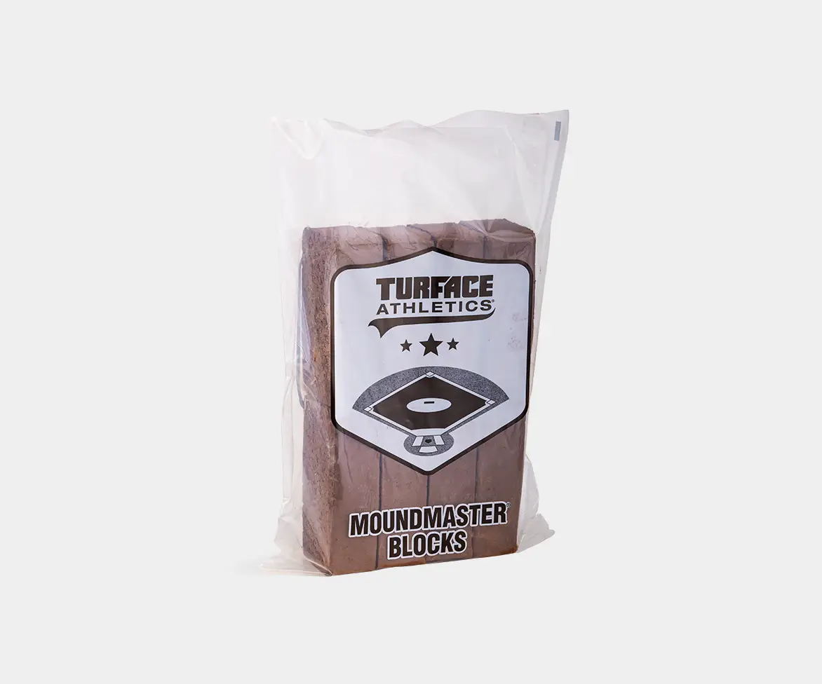 Clear plastic-wrapped package labeled “Turface Athletics MoundMaster Blocks,” showing stacked brown clay blocks for building or repairing pitcher’s mounds.
