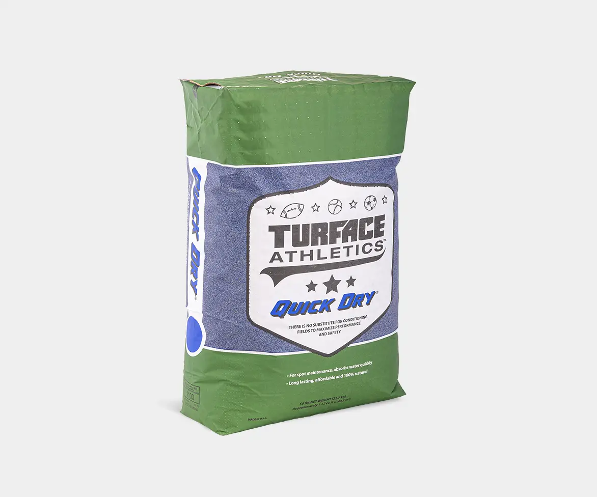 Green and blue bag of Turface Athletics “Quick Dry” product with a shield-style logo and text indicating it absorbs water quickly for field maintenance.