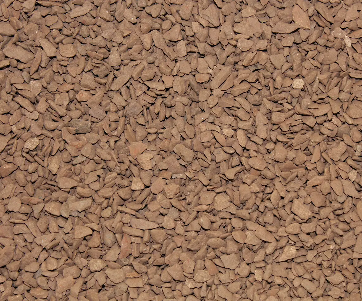 Close-up of brown crushed stone or granular infield material filling the frame.