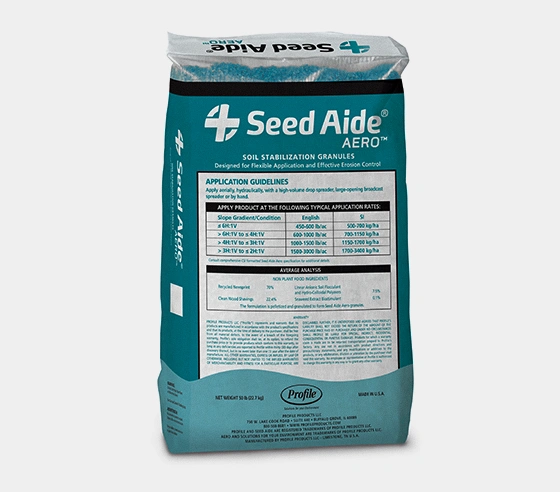 A bag of Seed Aide Aero soil stabilization granules stands upright. The bag is mostly teal with white and blue text, showing application guidelines, product information, and branding on the front.