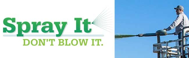 A man on a metal lift sprays a green substance from a large hose. Text next to him reads, Spray It. DONT BLOW IT. The sky is clear and blue.