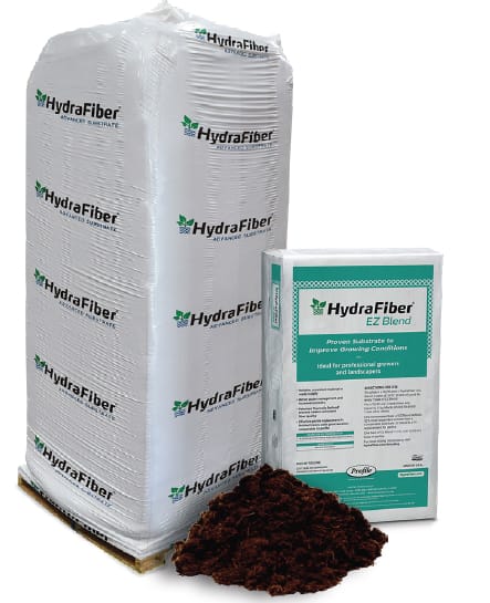 A large white HydraFiber bale, a smaller HydraFiber EZ Blend box, and a pile of brown substrate are shown. The packaging displays branding and product information.